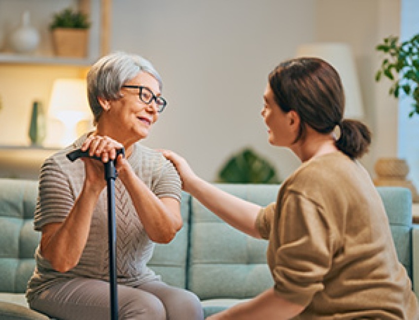 A caregiver speaks with an older woman.