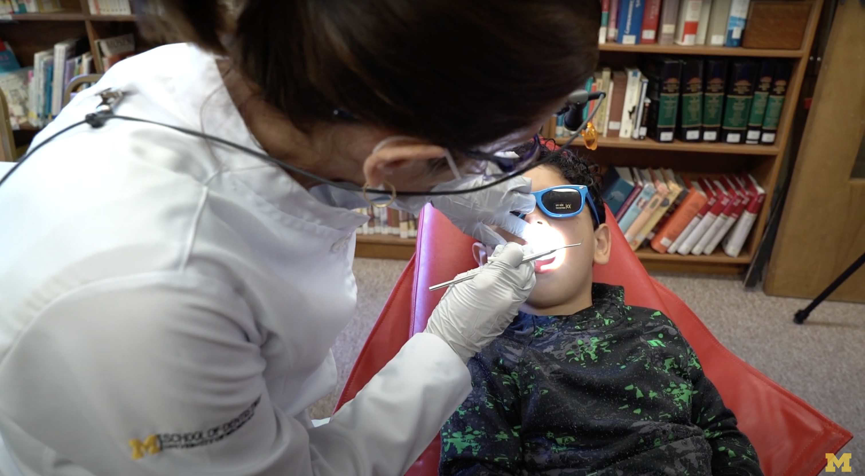A clinical trial participant receives an oral exam at school from a dental clinician on the the study. 