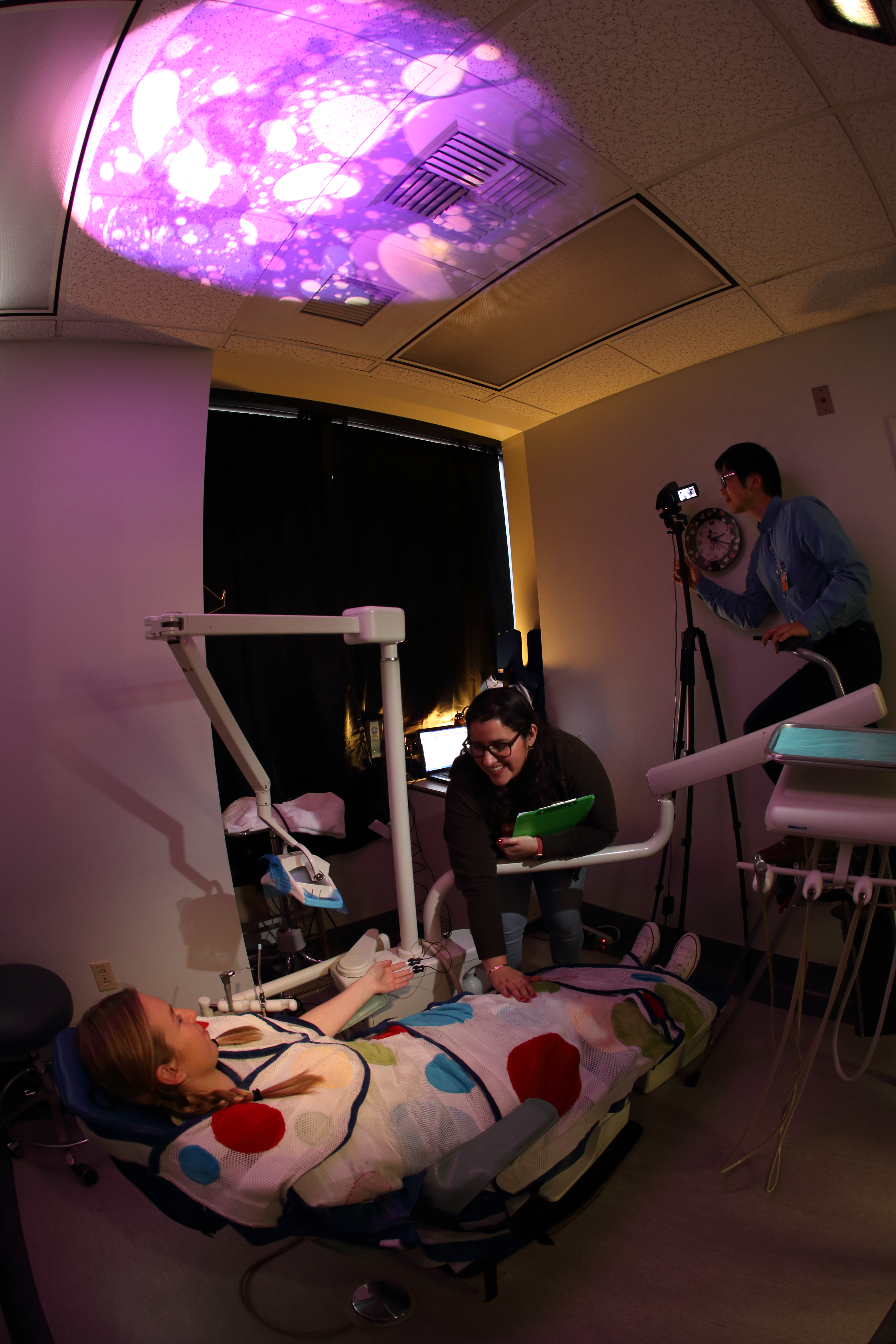 Scientists developed a sensory adapted dental environment that featured dim lights, a weighted wrap, calm music, and image projections on the ceiling for children with autism spectrum disorders. | Phil Channing/USC