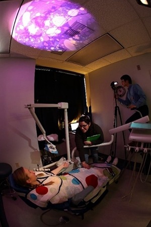 USC scientists developed a sensory adapted dental environment that featured dim lights, a weighted wrap, calm music, and image projections on the ceiling. 