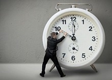 Person turning hands on over-sized clock