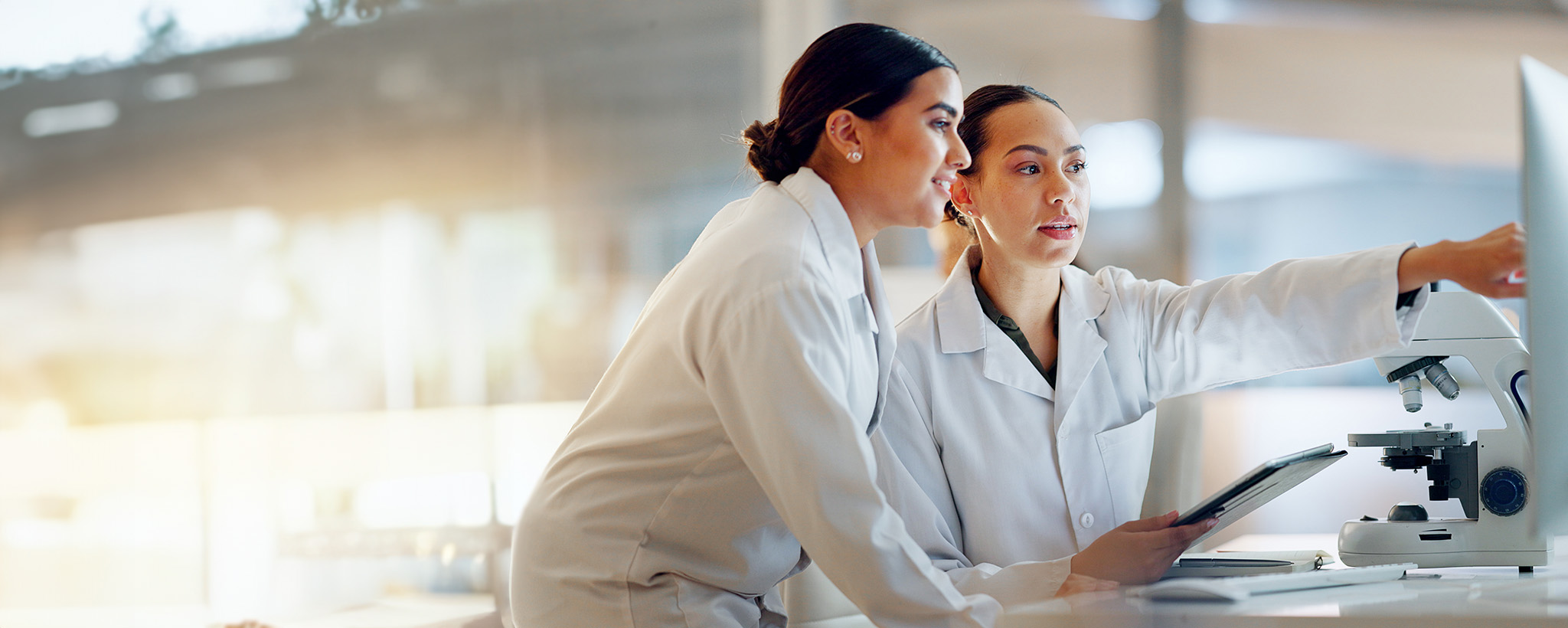 Two female researchers pointing at a screen