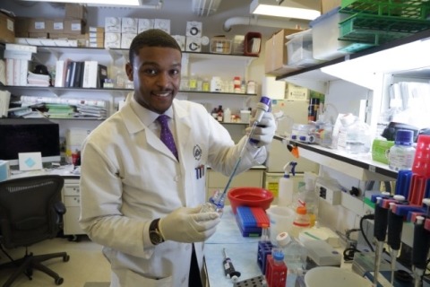 An african american researcher smiling while working in a lab