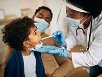 A dental clinician examining a child’s mouth.