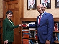 NIH Director Dr. Monica Bertagnolli greets Dr. John Nkengasong.