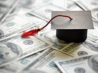 A graduation cap placed on top of $100 bills.