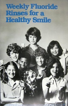 An ad shows a group of kids holding rinse cups and titled Weekly Fluoride Rinses for a Healthy Smile.