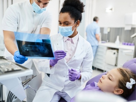 A photo of the physician chatting with her staff while treating a patient