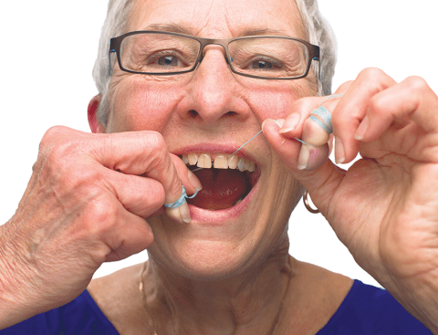 Ease the floss gently between the teeth until it reaches the gumline (don’t force the floss into place — this could harm the gums).