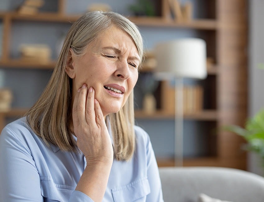 Woman touching her jaw in pain