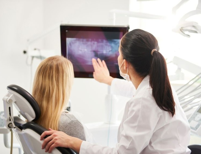 A dentist and a patient looking at xrays on a screen