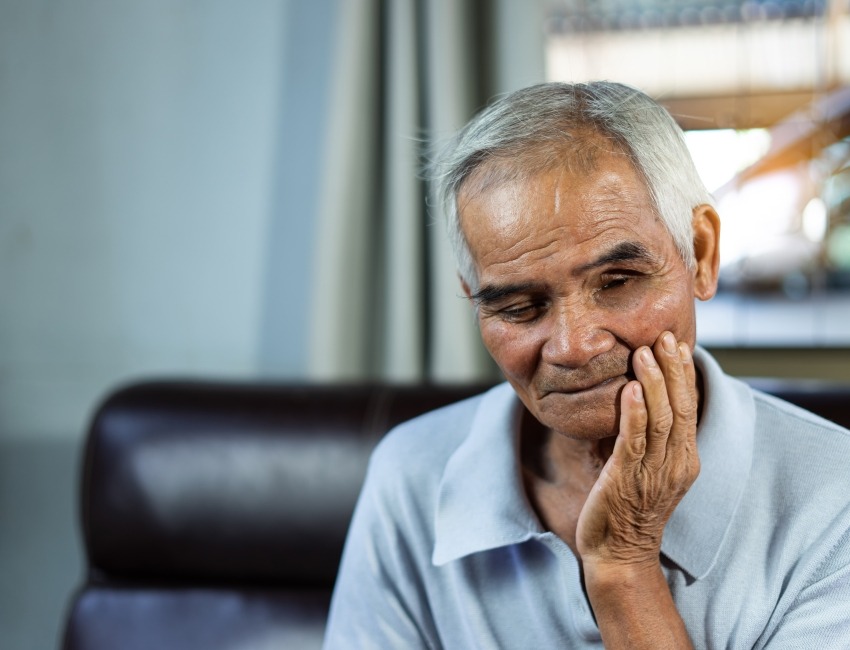 An older man experiencing mouth pain