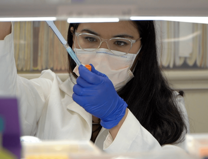 Female researcher using a syringe and working in a lab