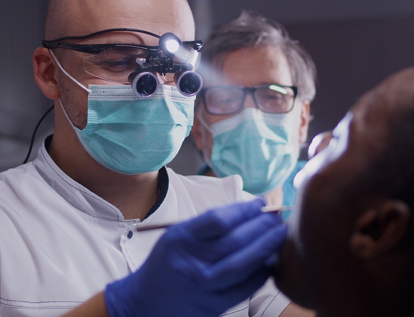 Two dental professionals examining a patient.