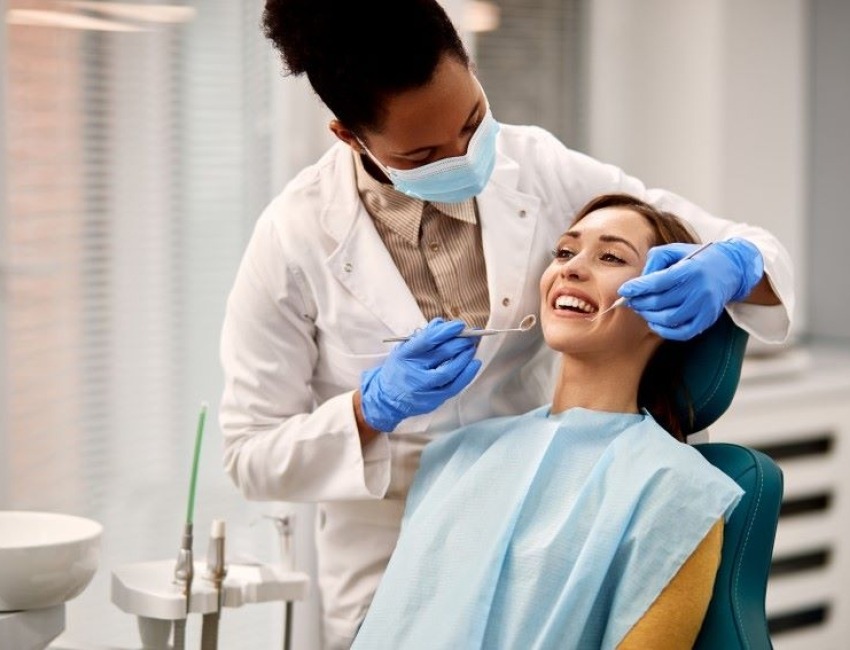 A dentist examines a female patient.
