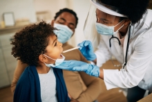 A photo of a doctor giving a child an oral screening