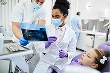Dental professionals working in an office setting with a patient.