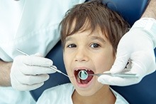 Child getting oral exam by dentist.