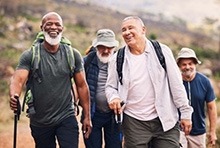 A group of people are hiking on a trail while smiling.