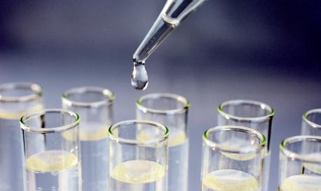 Liquid being dropped into glass tube from a glass pipette